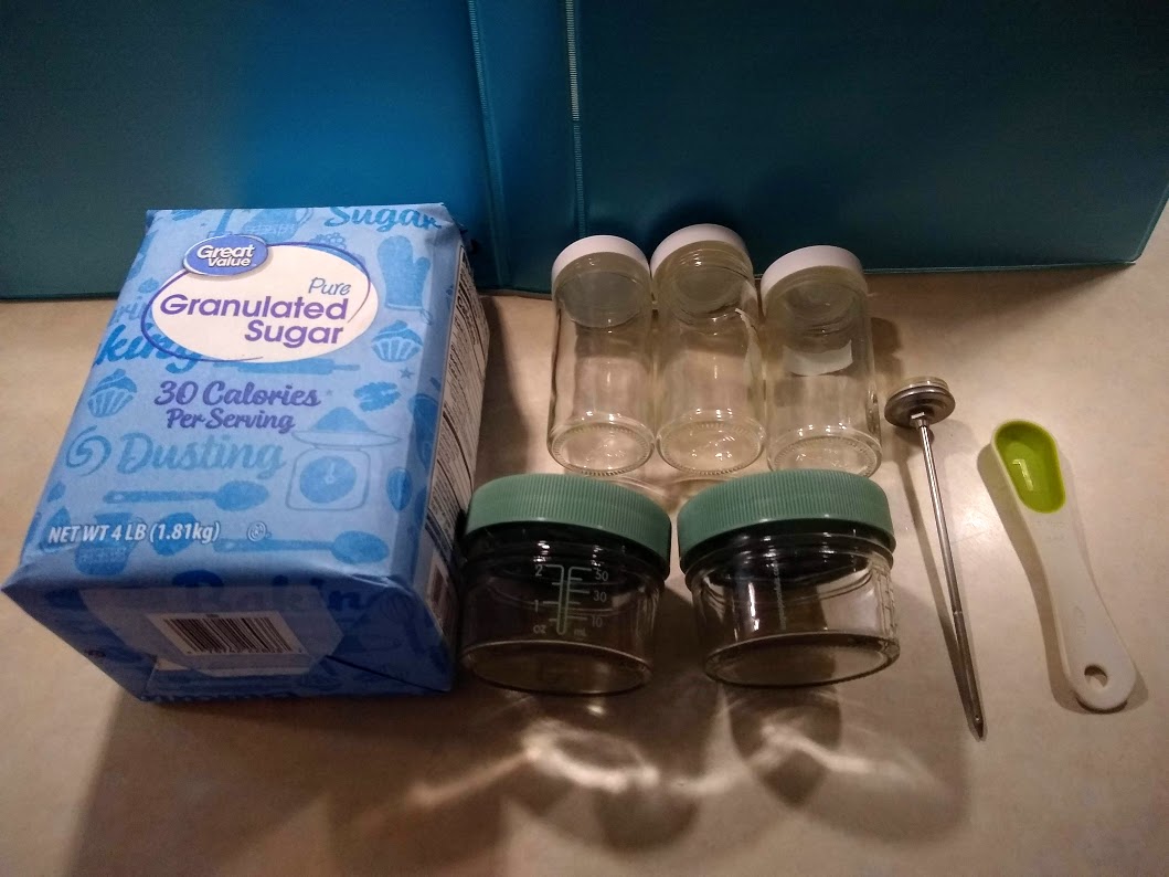 Image of the sugar water set up, sugar thermometer, teaspoon, and jars.